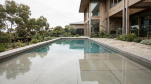 High-end tiled concrete swimming pool with precision grout lines and crystal-clear balanced water in a modern luxury home